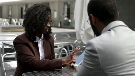 serious business partners talking at outdoor cafe.