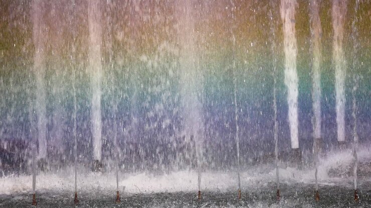 Colorful rainbow forms in fountain water spray