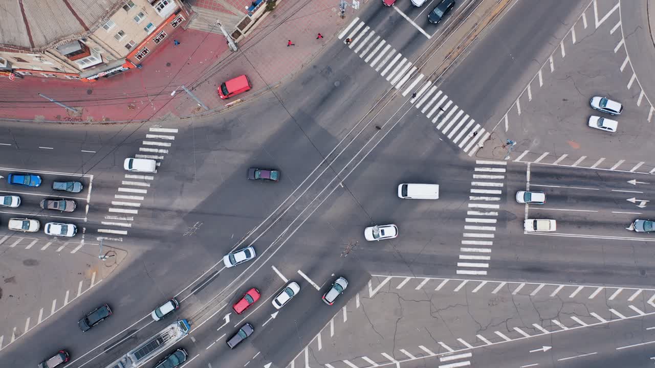 Aerial view of a busy city intersection with cars and pedestrian crossings