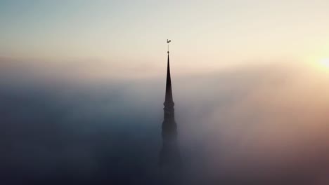 aerial drone view through clouds on church in old town riga, latvia, europe