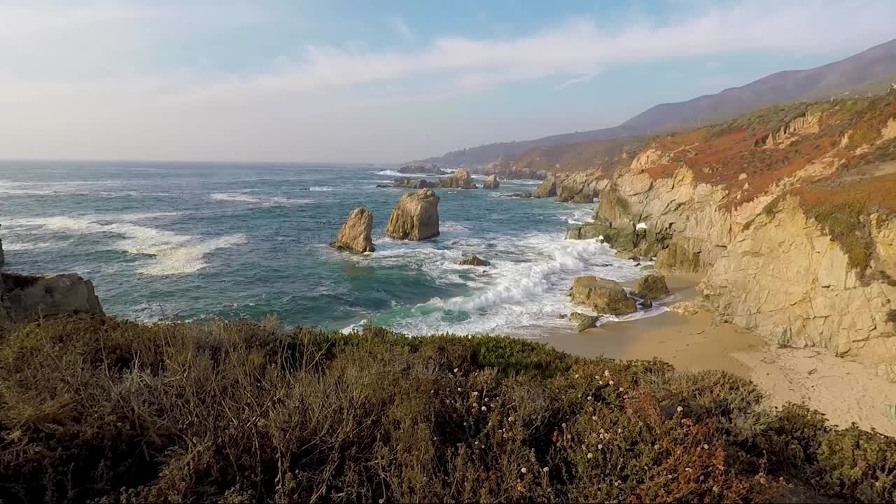 여름에 씨 스택으로 해변에 부서지는 파도