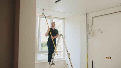 painter working on ceiling of a room under construction