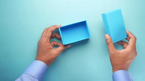 hands holding a light blue box