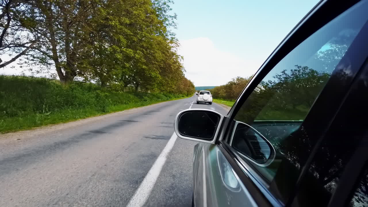 Driving car on the road in a village of Moldova. Side view outside the car