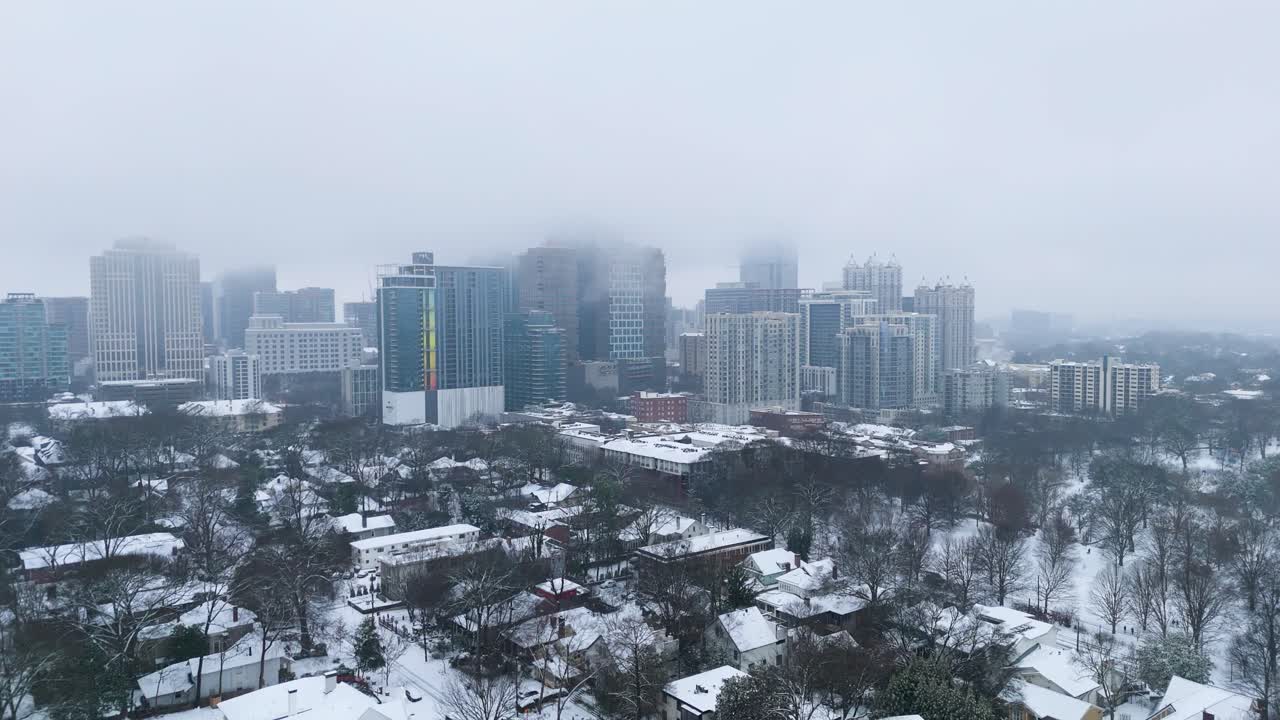 Rotating aerial shot around snow covered Midtown buildings in Atlanta Georgia on January 10th 2025.