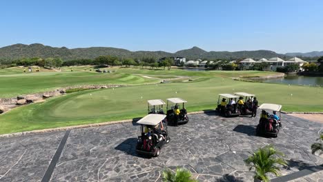 group of golf carts convene then disperse on course