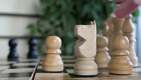 Playing-chess-game-white-pieces,-woman-hand-close-up