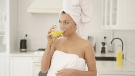 hermosa mujer después del baño bebiendo jugo