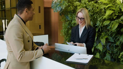 blonde receptionist at the entrance of a hotel