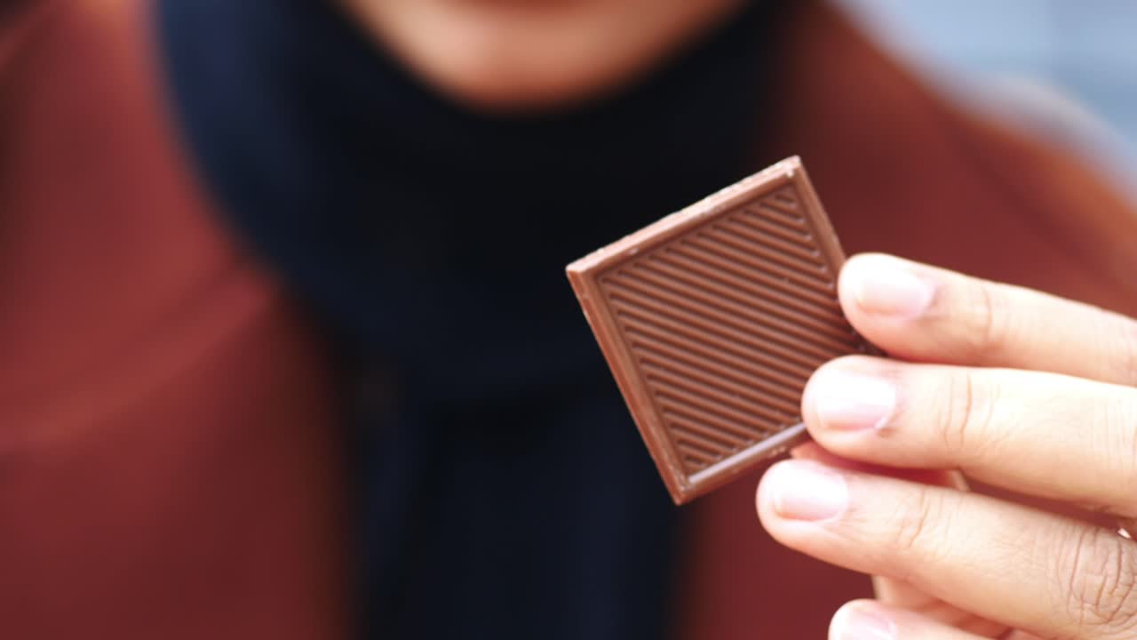 persona que sostiene una barra de chocolate