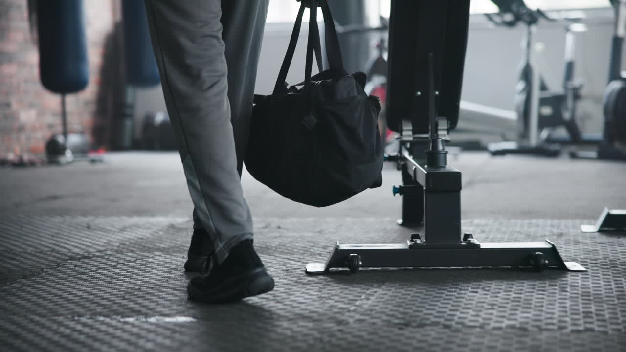 A man walks into a gym with a duffel bag