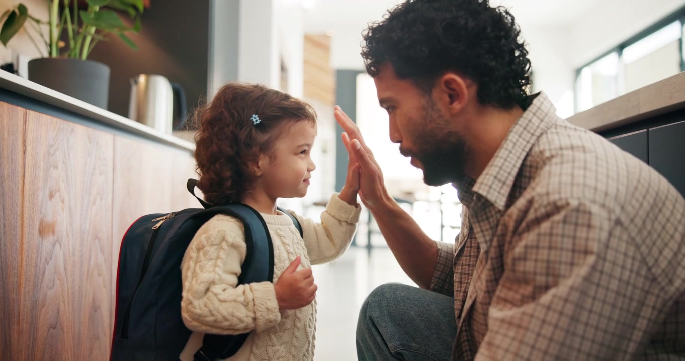 Father Helping Daughter Put On Backpack Before School