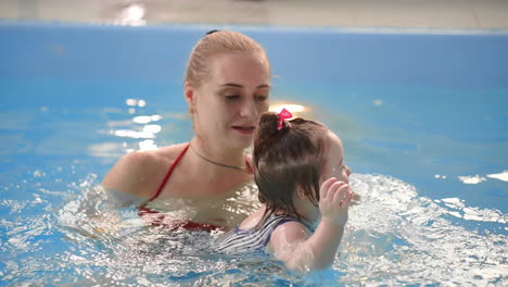 happy smiling toddler is jumping and diving under the water in the swimming pool. an underwater shot. slowmotion