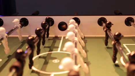 intense foosball match with black and white teams