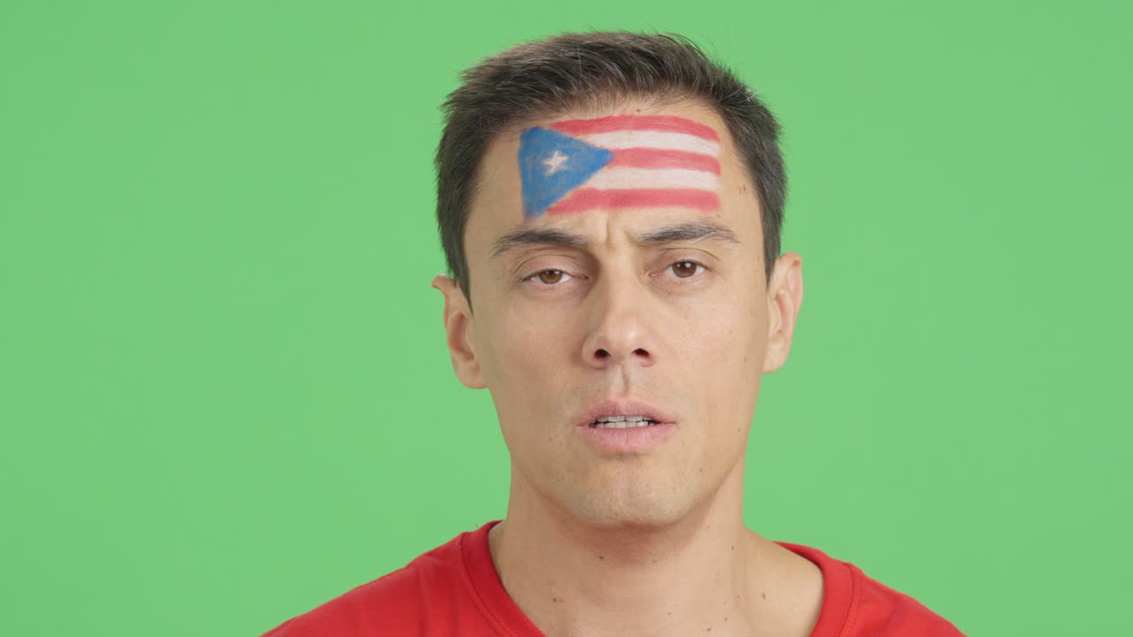 Man with a puerto rican flag painted on the face smiling