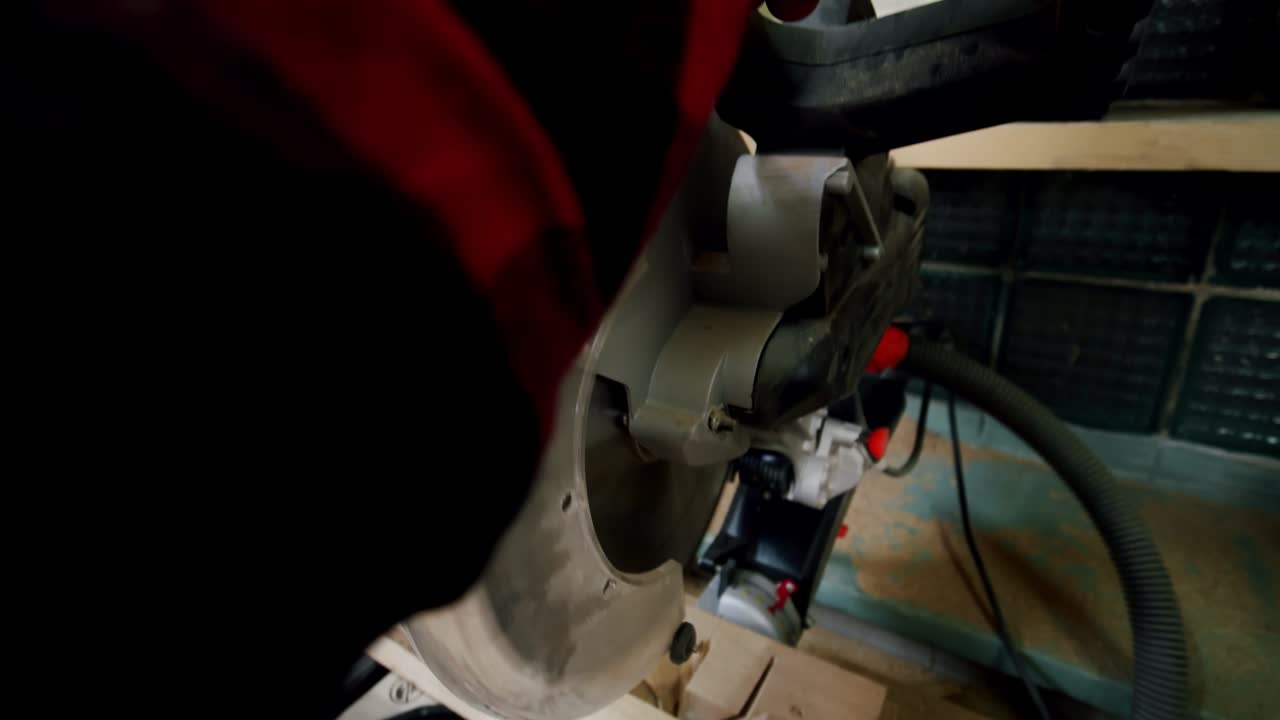 el maestro corta una tabla de madera con una sierra circular en el taller de carpintería de un pequeño fabricante de muebles.