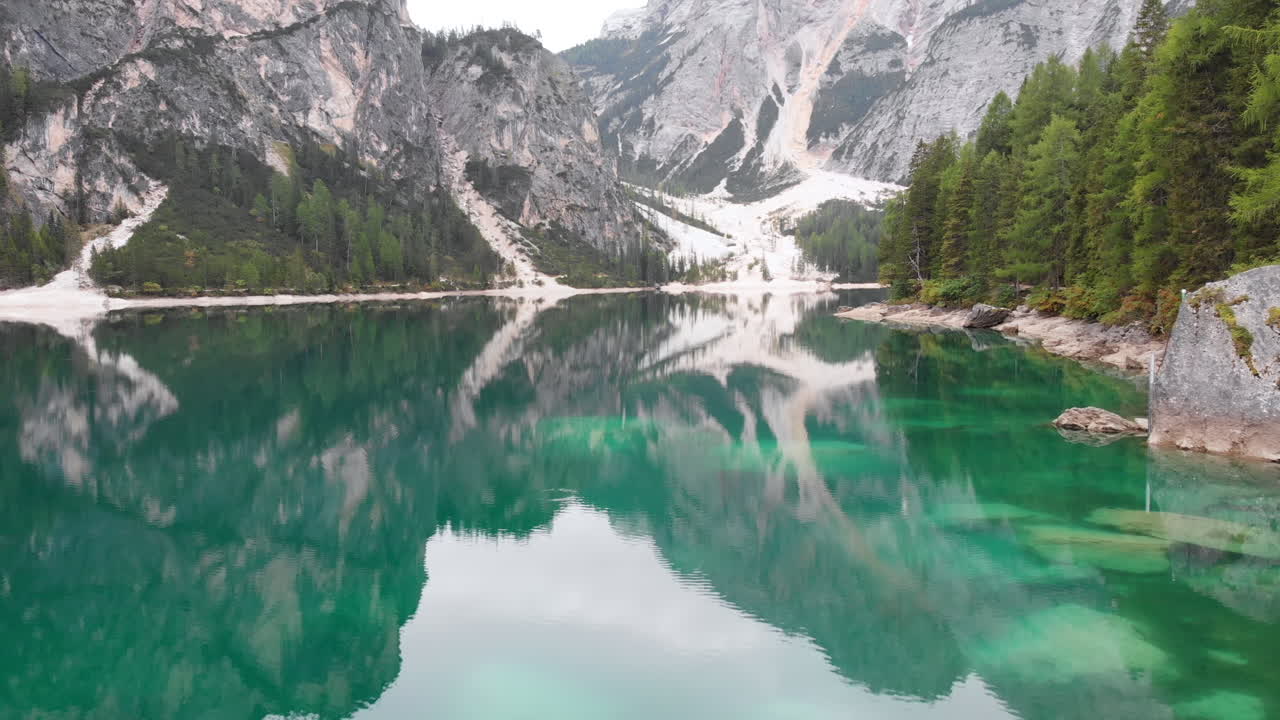 Inquadratura aerea da drone sul lago di Braies che rivela la splendida natura circostante, Dolomiti, Italia.