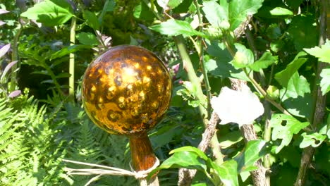 bola de rosa brillante dorada en un jardín entre flores