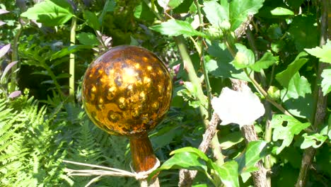 golden shiny rose ball in a garden between flowers