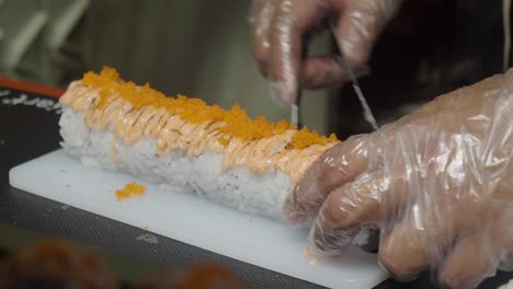 preparing a delicious sushi roll with roe and sauce