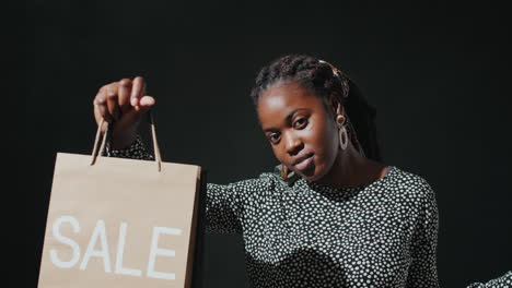 retrato de una hermosa mujer afroamericana con una bolsa de compras en venta