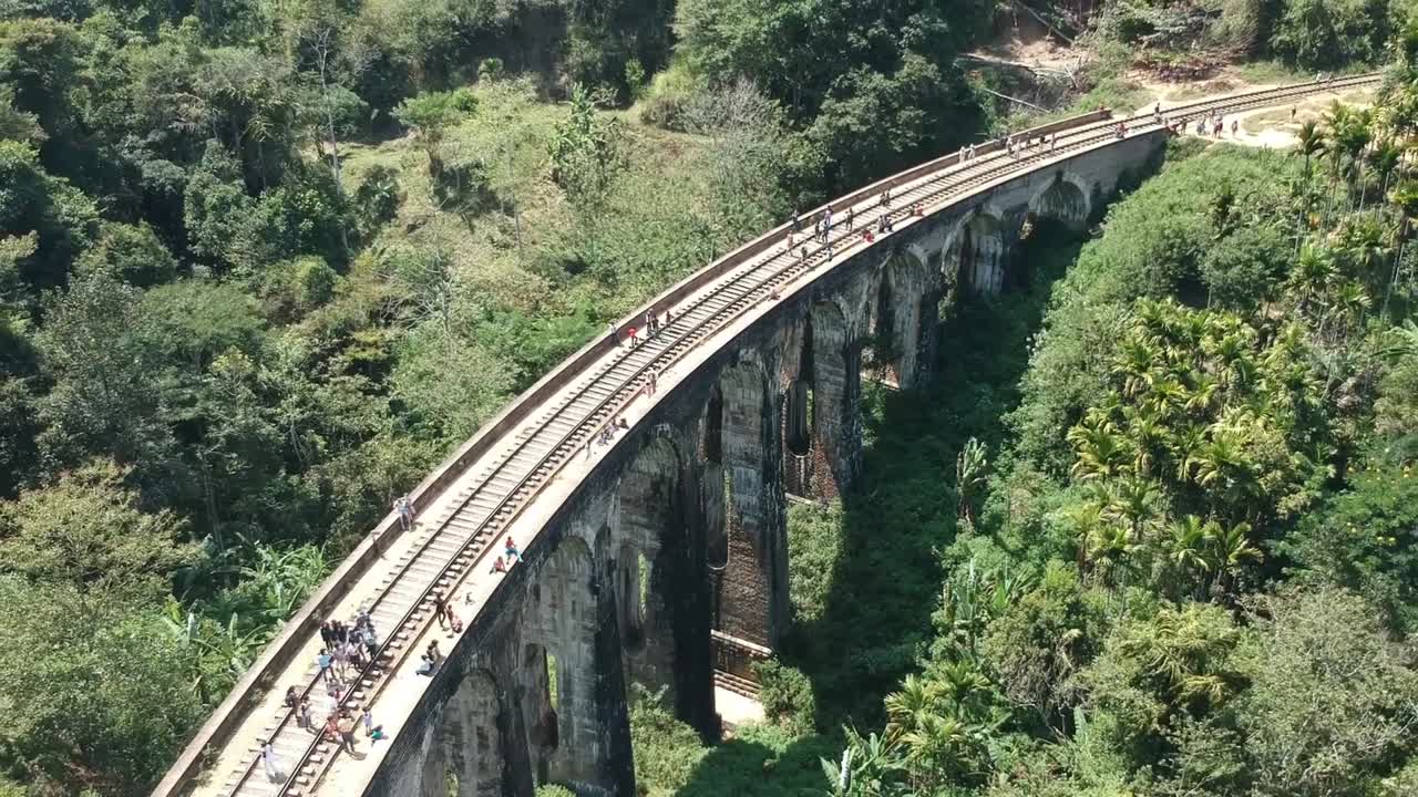 Aerial Over Nine Arch Bridge With Visitors Walking Across In Sri Lanka. Follow Shot