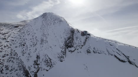 Aerial-view-of-ski-lift-ending-on-summit-of-Kitzsteinhorn-during-sunny-day-at-sky