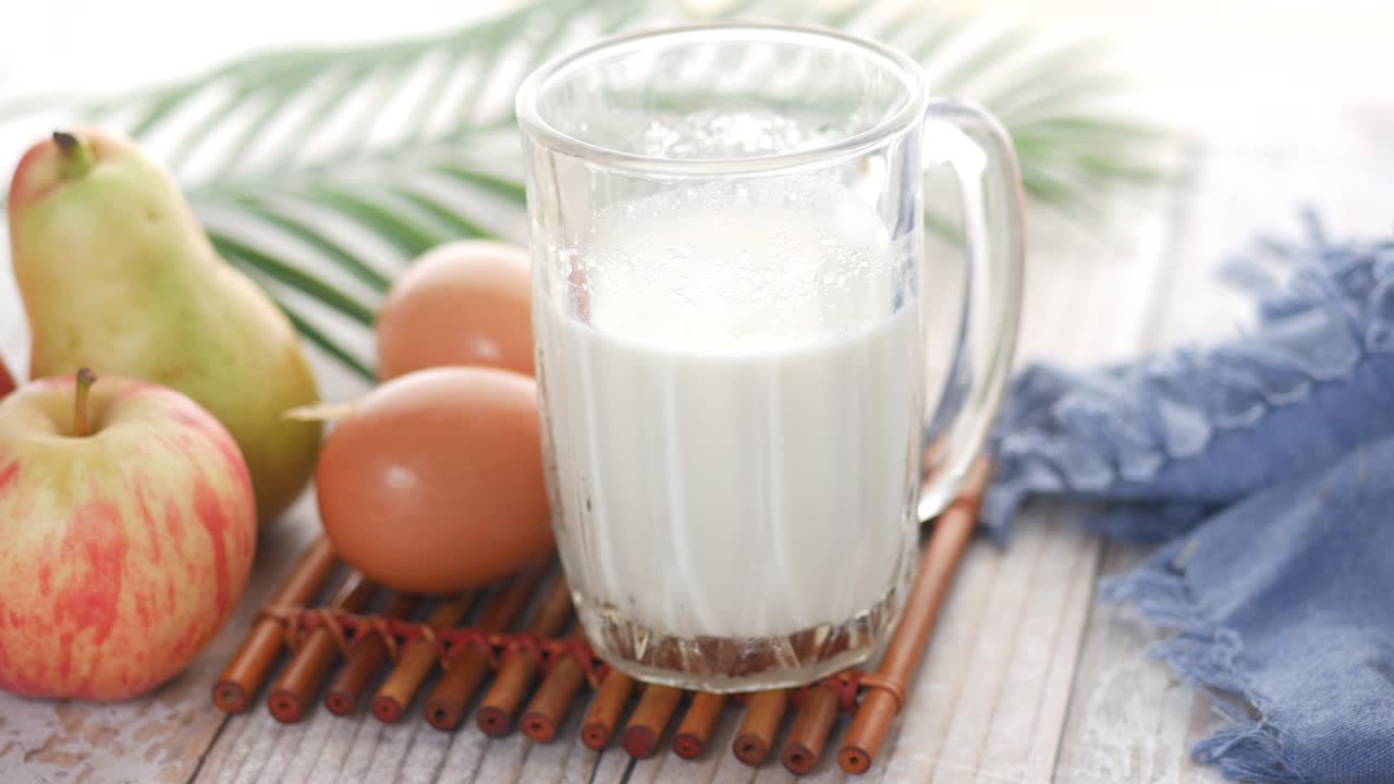 Primo piano di bicchiere di latte e cucchiaio sul tavolo