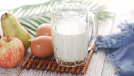 Close up of glass of milk and spoon on table