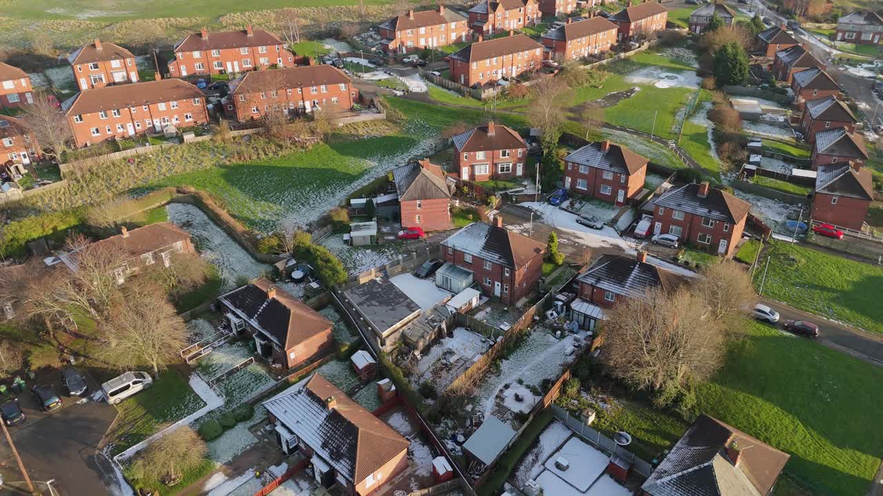 Drone's-eye winter view captures Dewsbury Moore Council estate's typical UK urban council-owned housing development with red-brick terraced homes and the industrial Yorkshire