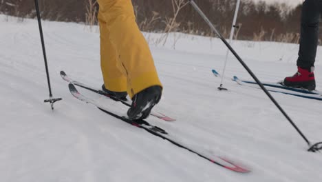 Two-female-friends,-cross-country-skiing-in-Homer-Alaska