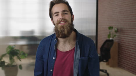 retrato de un atractivo joven hipster con barba mirando a la cámara pensando pensativo hombre relajado simling confiado en el espacio de trabajo de la oficina moderna