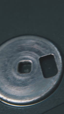 motion along vintage diskette in black plastic case lying on clean white background extreme close view