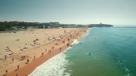 piękna portugalska plaża w letni dzień z ludźmi i surferami