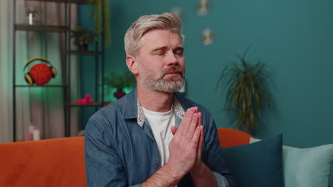 Middle-aged-mature-old-man-praying-sincerely-with-folded-arms-asking-God-for-help,-begging-apology