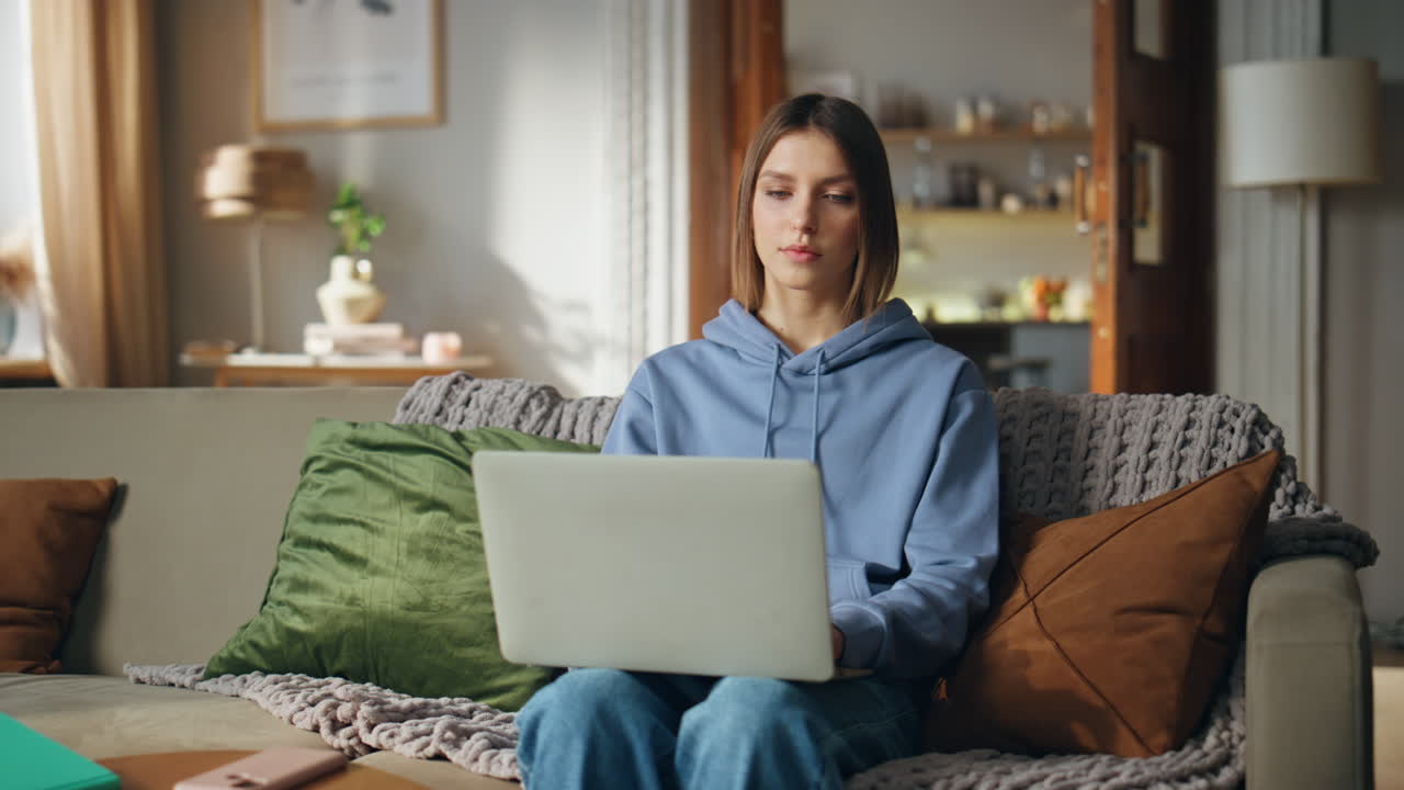 Woman using laptop on couch at home