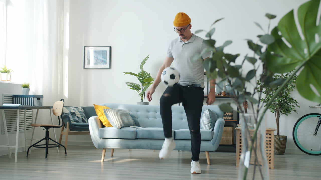 Man Playing Soccer in Living Room
