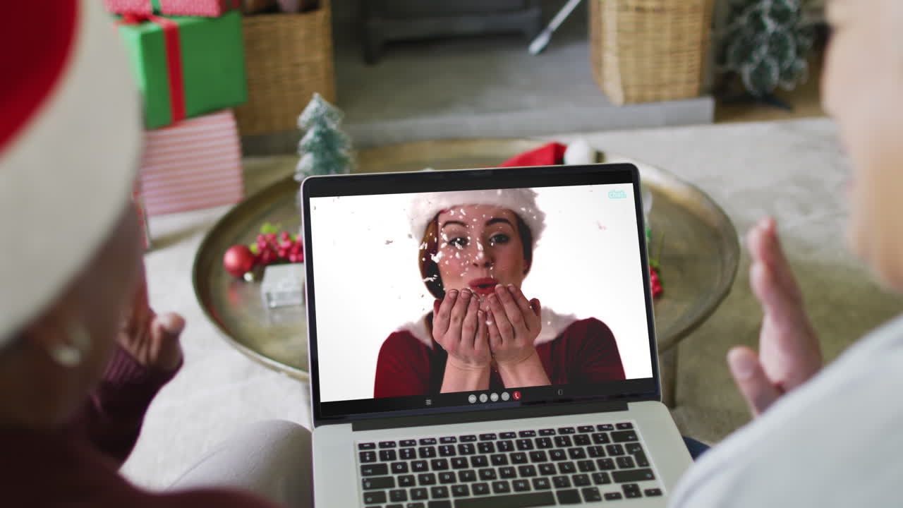 diversas amigas mayores que usan una computadora portátil para una videollamada de navidad con una mujer feliz en la pantalla