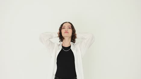 stylish woman with curly hair posing in a studio