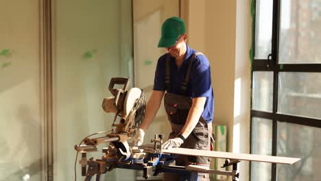 man working with a miter saw on a construction site