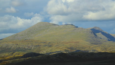 cumulonimbus cloud shadows moving across mountainous rugged landscape