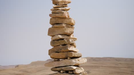 un primer plano inclinado hacia arriba de piedras paradas una encima de la otra en forma de torres en el cráter ramon