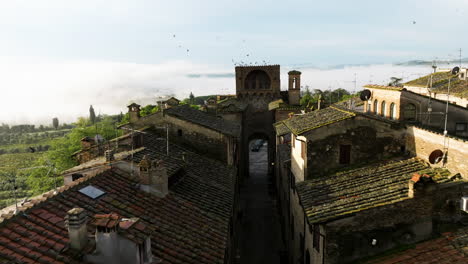 ancient architecture in medieval village at san gimignano with misty hills on background in tuscany, italy