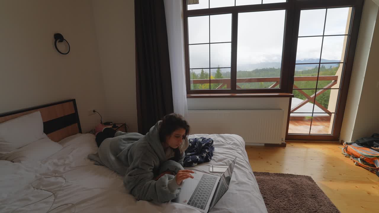 산의 오두막에서 노트북을 사용하는 여자