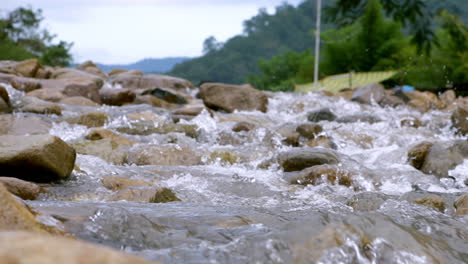 Clear-stream-running-through-stone-boulders-Abundant-river-flowing-in-slow-motion