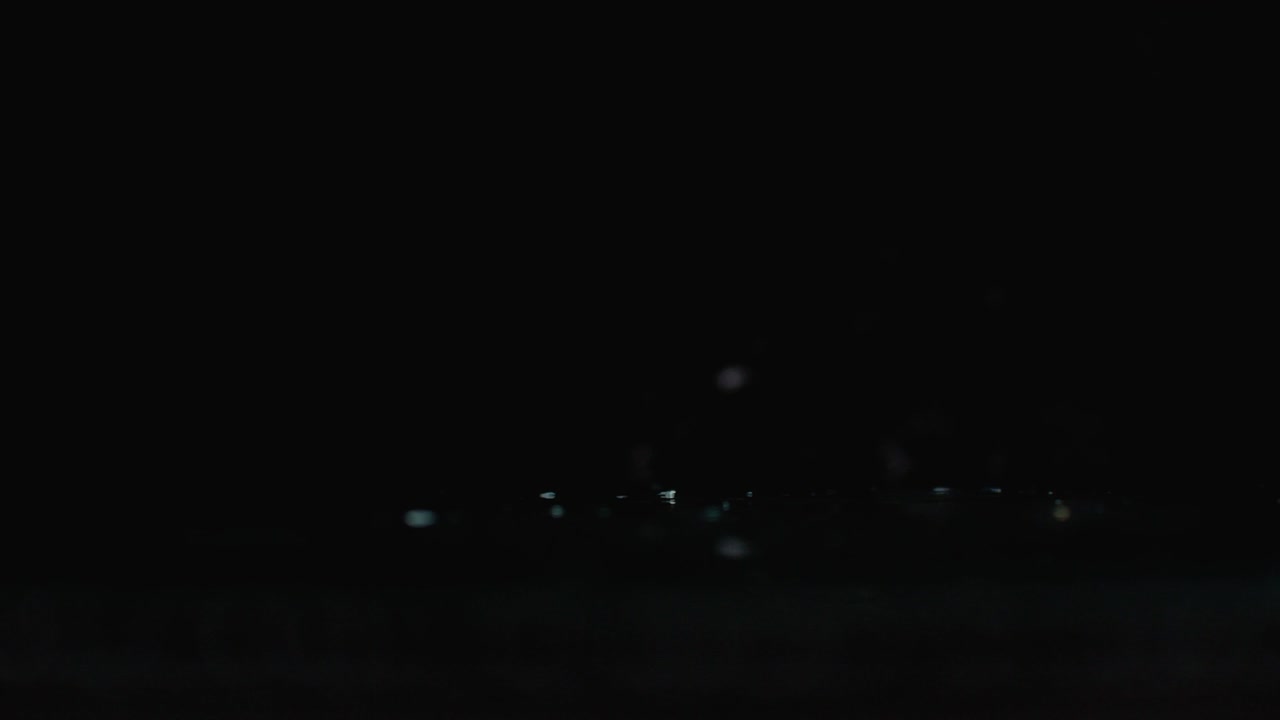 절단 된 라임 링은 어두운 배경에 유리 위에 물 어리와 함께 떨어집니다. 맛있는 호두 과일