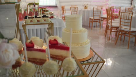 a beautifully decorated wedding dessert table featuring a three-tiered white cake, cake pops, and assorted pastries. perfect for themes related to weddings, celebrations, desserts, and event decor.