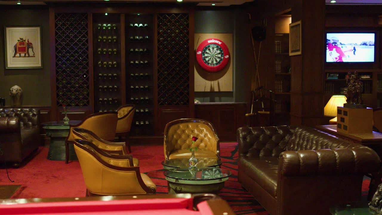 Elegant lounge bar with leather sofas, armchairs, warm lighting, slow camera pan, sophisticated ambiance