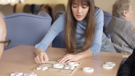 girl explaining rules of a game to a senior man