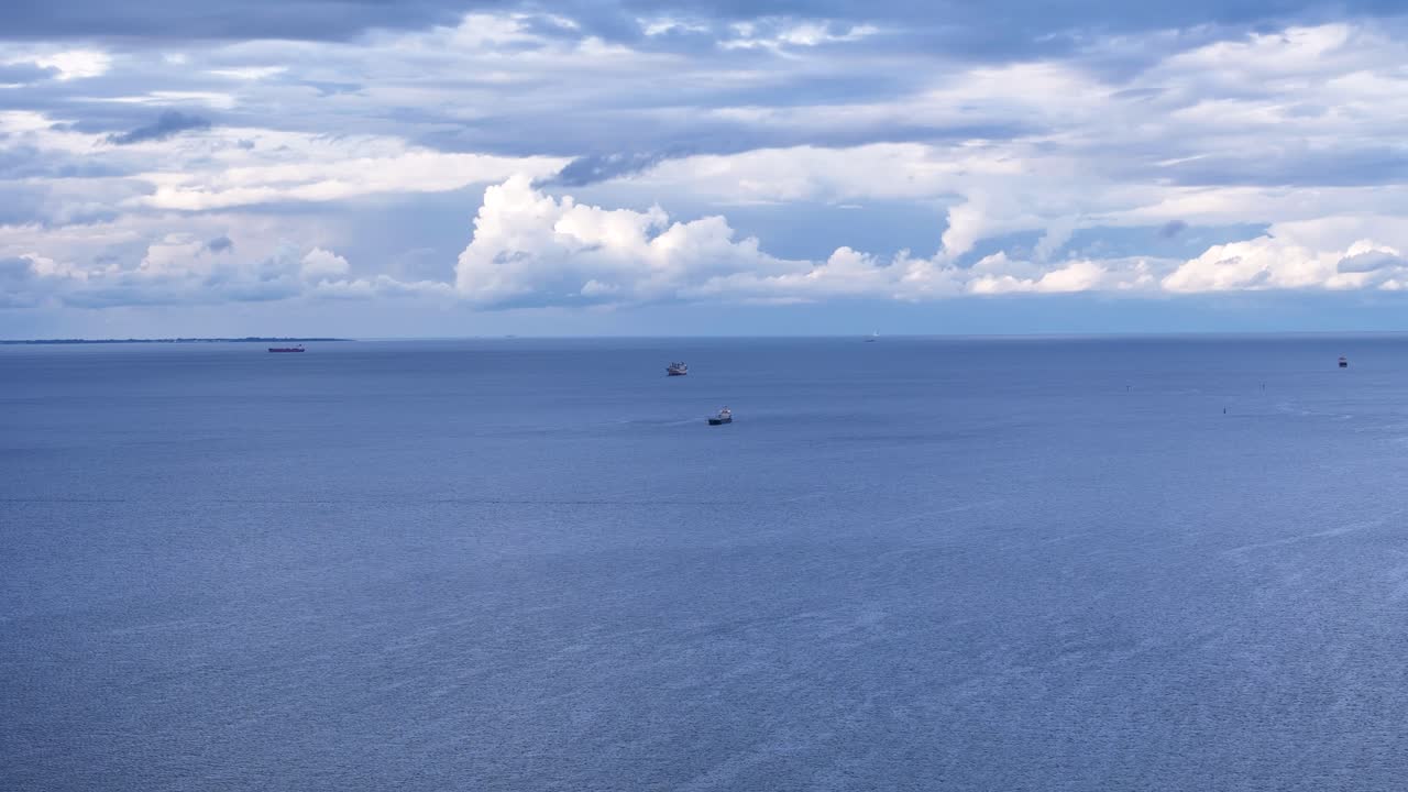 Calm Ocean Scene with Cargo Ships on a Cloudy Day